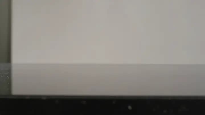 Metal press descending onto a glass vessel