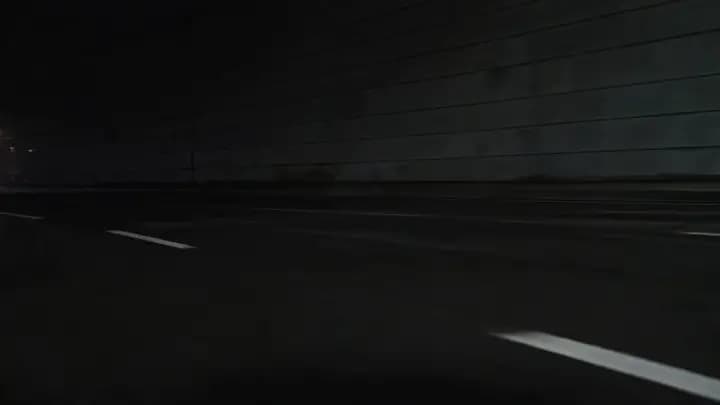 A red sports coupe exploding out of a tunnel into reflective city light with a premium commercial finish.